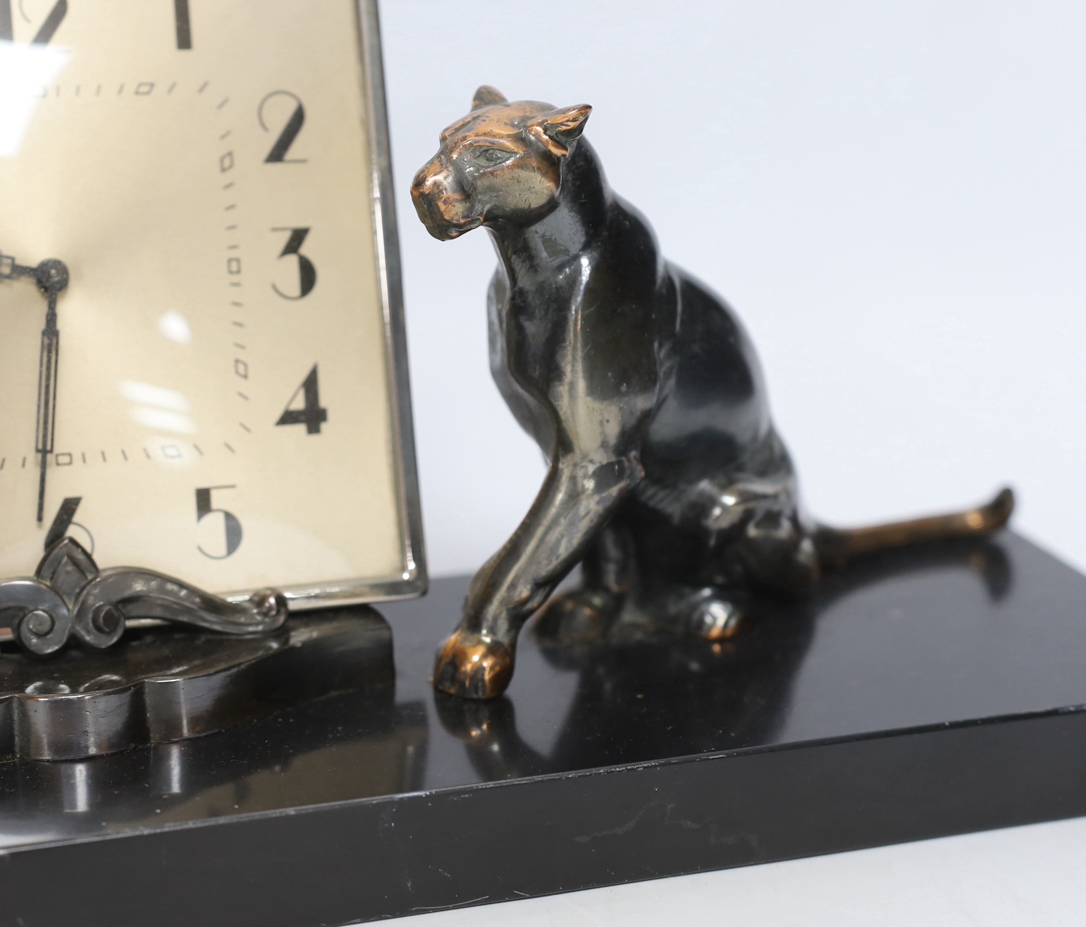 A patinated spelter Art Deco clock surmounted with two panthers, 40cm high